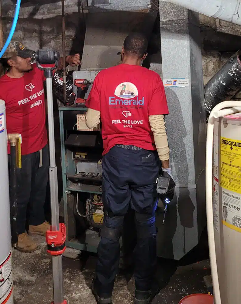 Emerald technicians removing an old furnace during a free Feel the Love HVAC replacement for a Western NY community hero