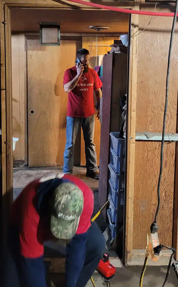 Coordinating the Feel the Love furnace installation, an Emerald tech takes a call while the crew works in Depew, NY