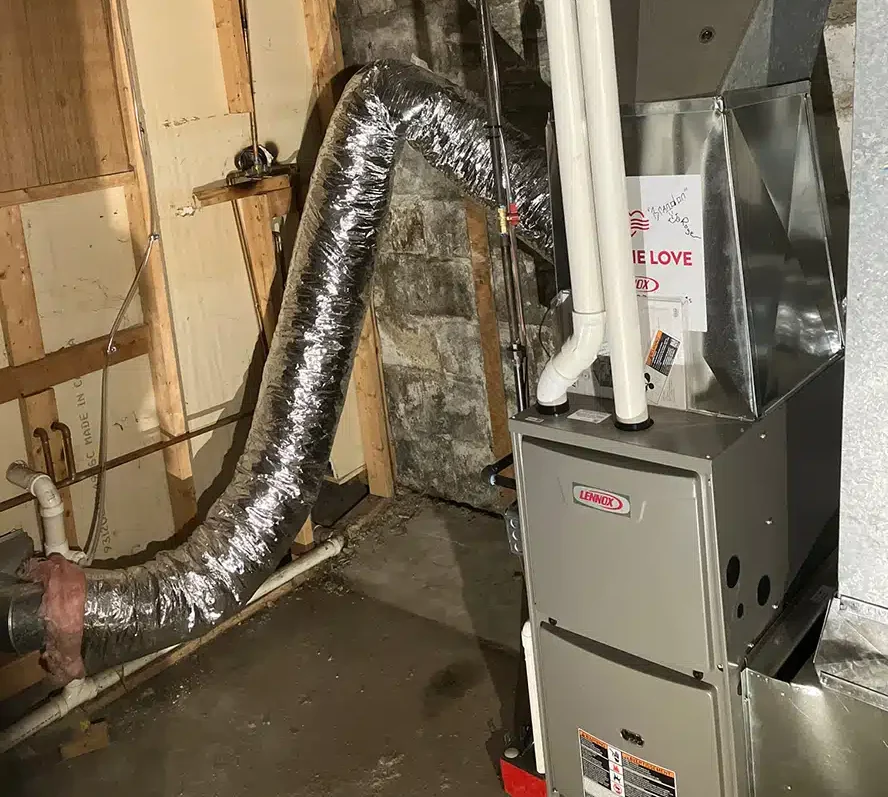 Lennox furnace with Feel the Love signage installed in a Western NY basement by Emerald Heating & Cooling's volunteer team.