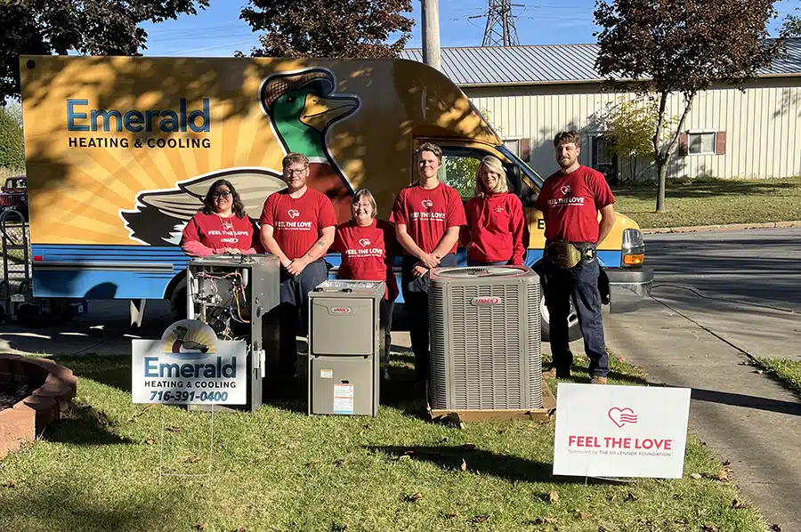 Six Emerald volunteers in Feel the Love shirts after completing a full HVAC system donation in Erie County, New York