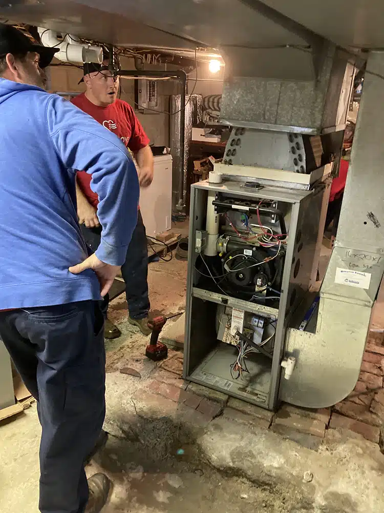 Feel the love team removing old furnace and installing new Lennox furnace in Western NY home