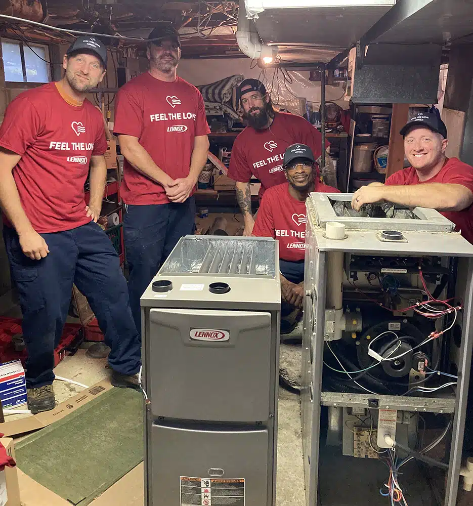 Emerald Heating & Cooling Feel the Love team smiling beside a new Lennox furnace at a Western NY home