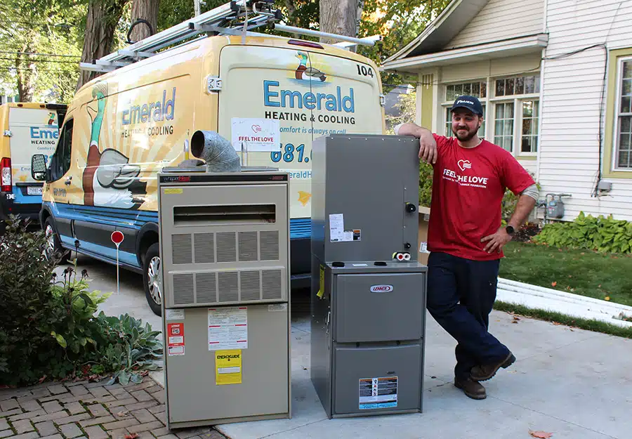 An Emerald Heating & Cooling tech poses beside the old unit and a brand-new Lennox furnace for a Depew, NY recipient