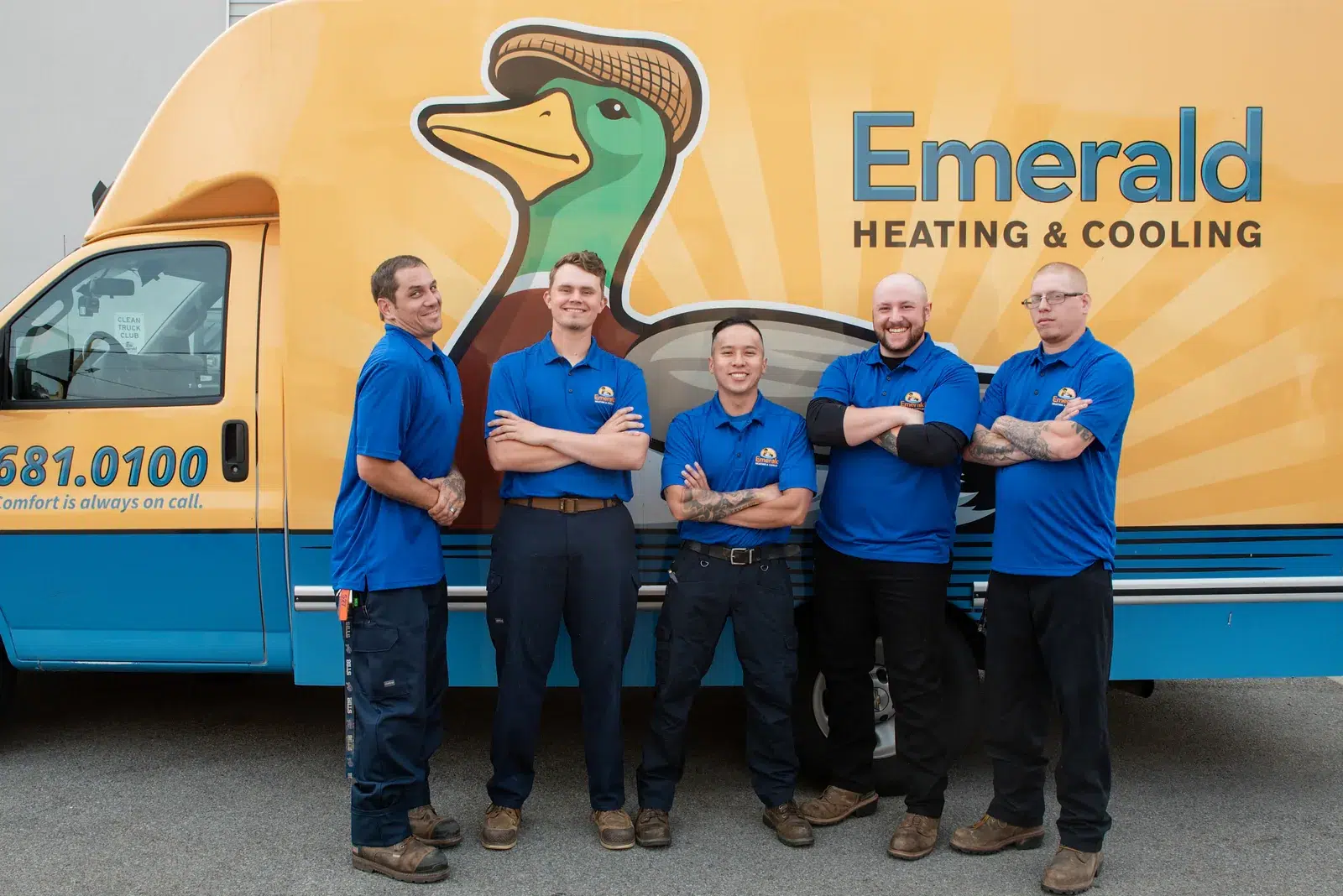 Emerald Heating & Cooling install technicians standing in front of a branded service van