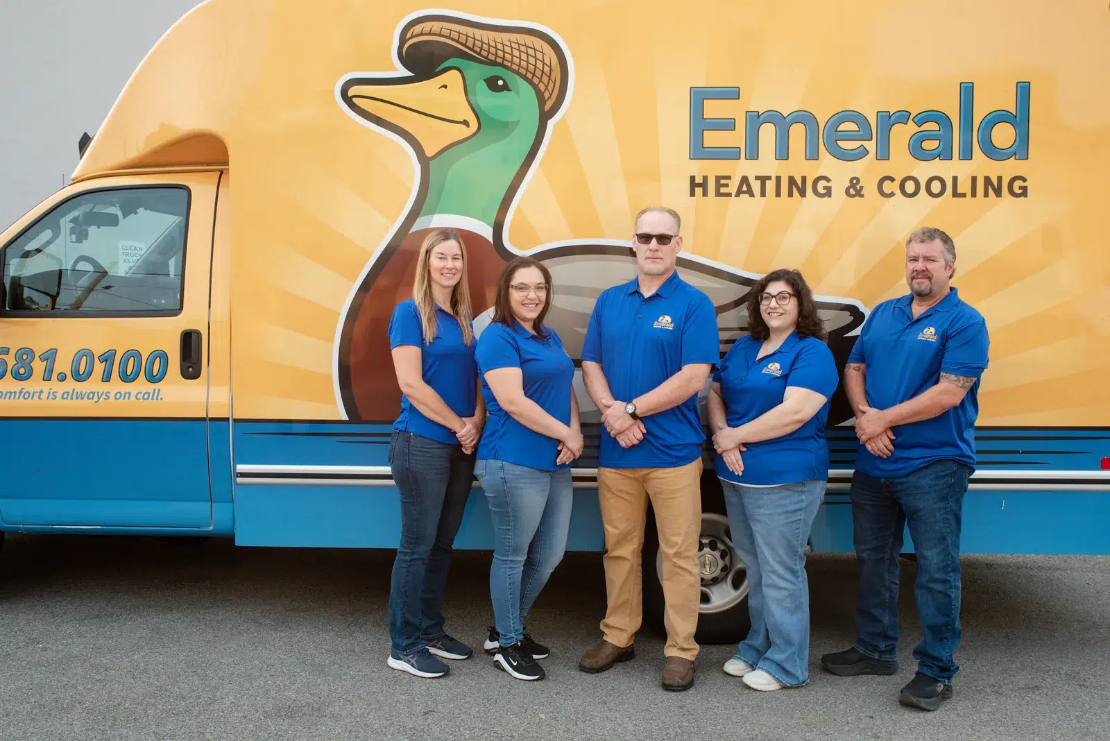 Emerald Heating & Cooling staff members smiling beside a branded service van in Depew, NY