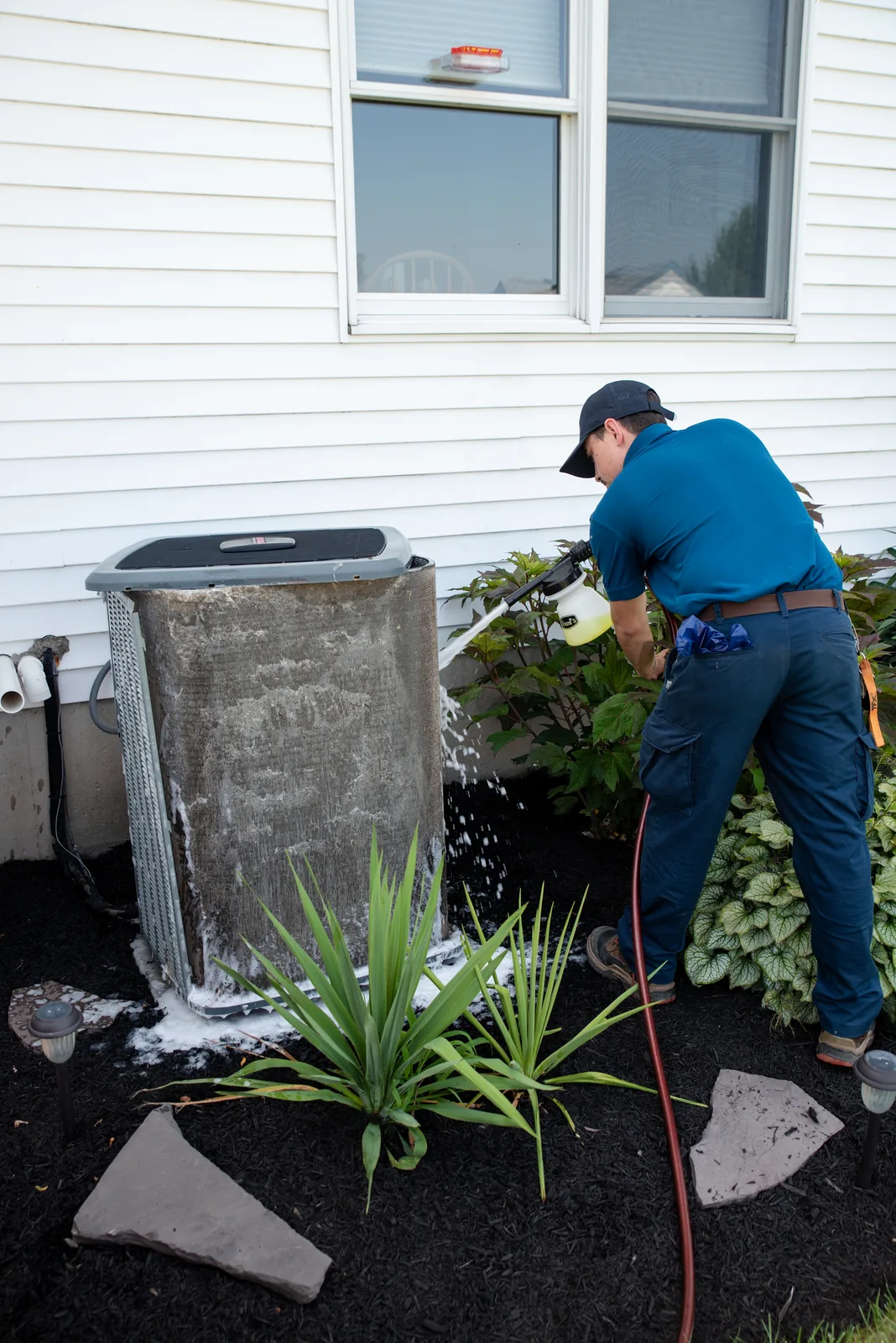 Emerald technician finishing an air conditioning maintenance visit outside a Western NY home