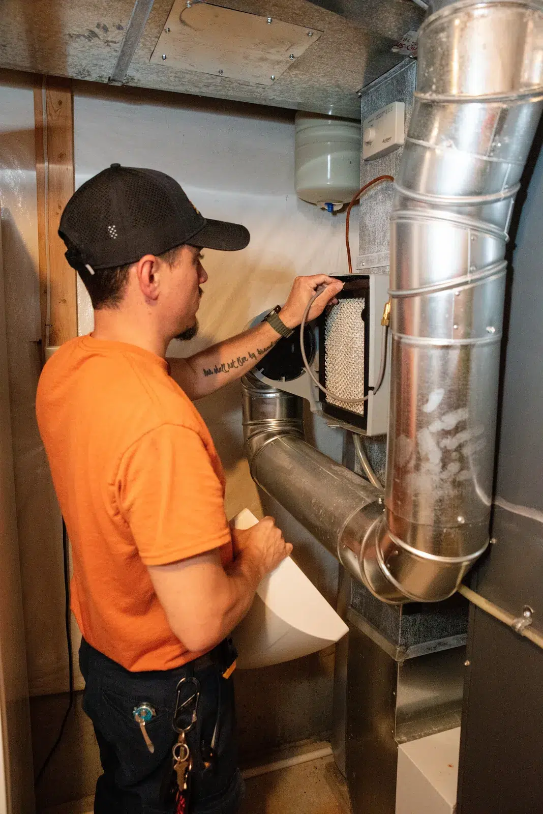 Emerald technician replacing a filter in the ductwork of a Western NY home