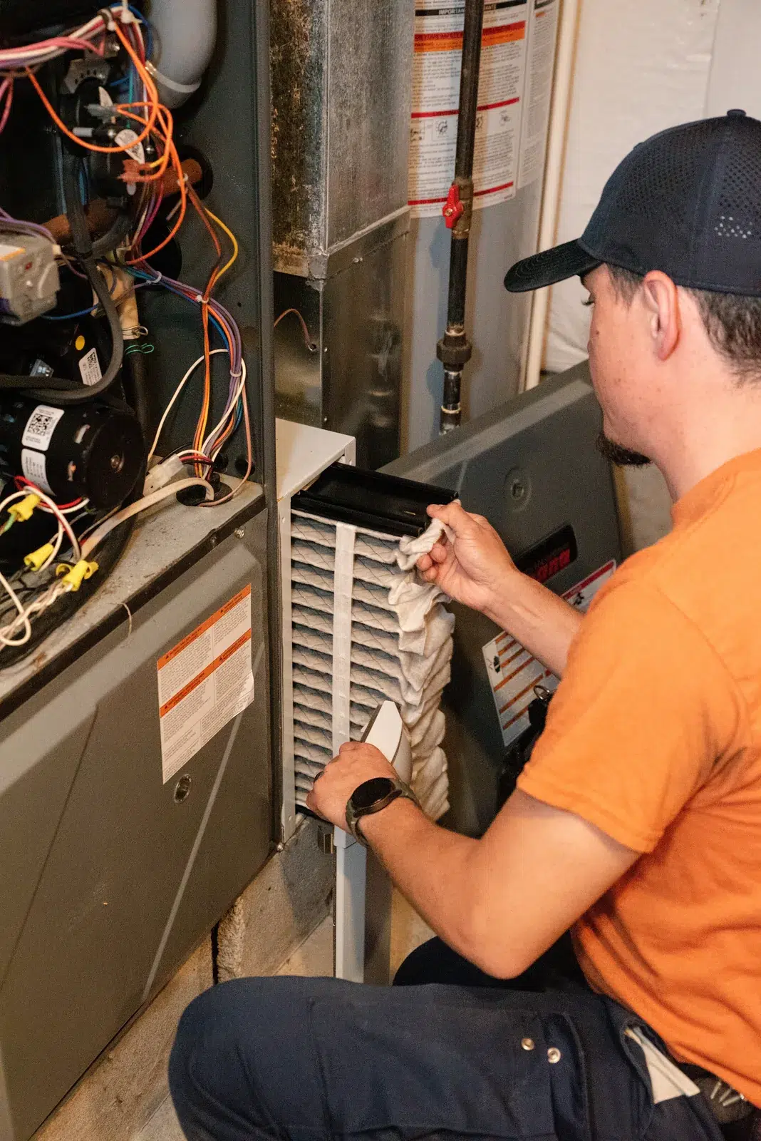 Emerald technician running diagnostics on an open gas furnace during a heating service call