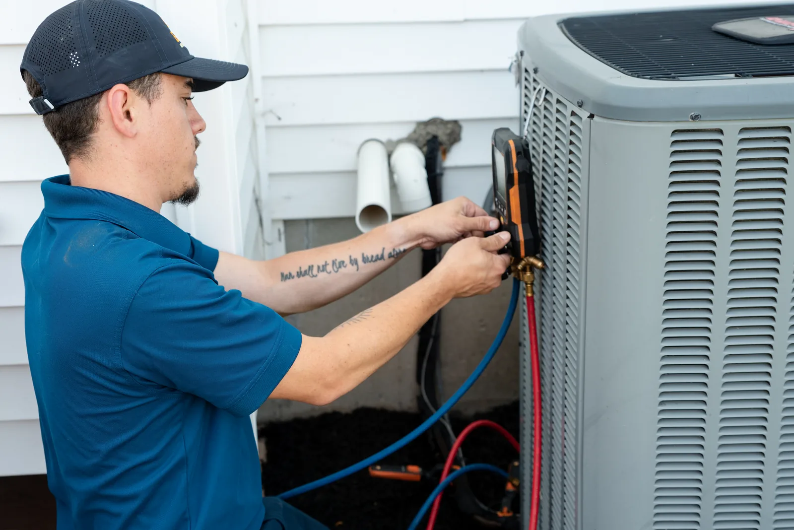Emerald technician connecting service gauges to an outdoor air conditioning unit