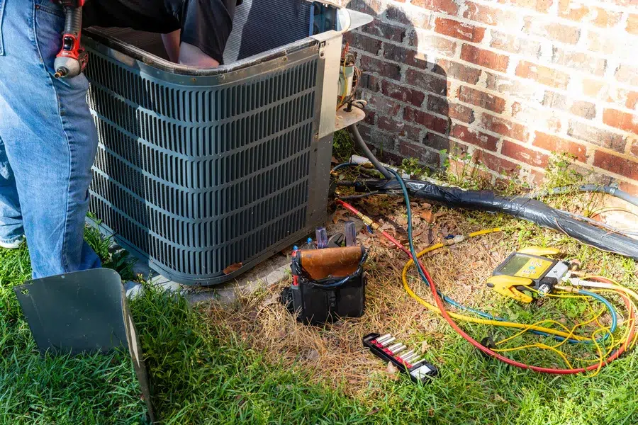 Depew HVAC technician performing AC maintenance on a residential central air condenser
